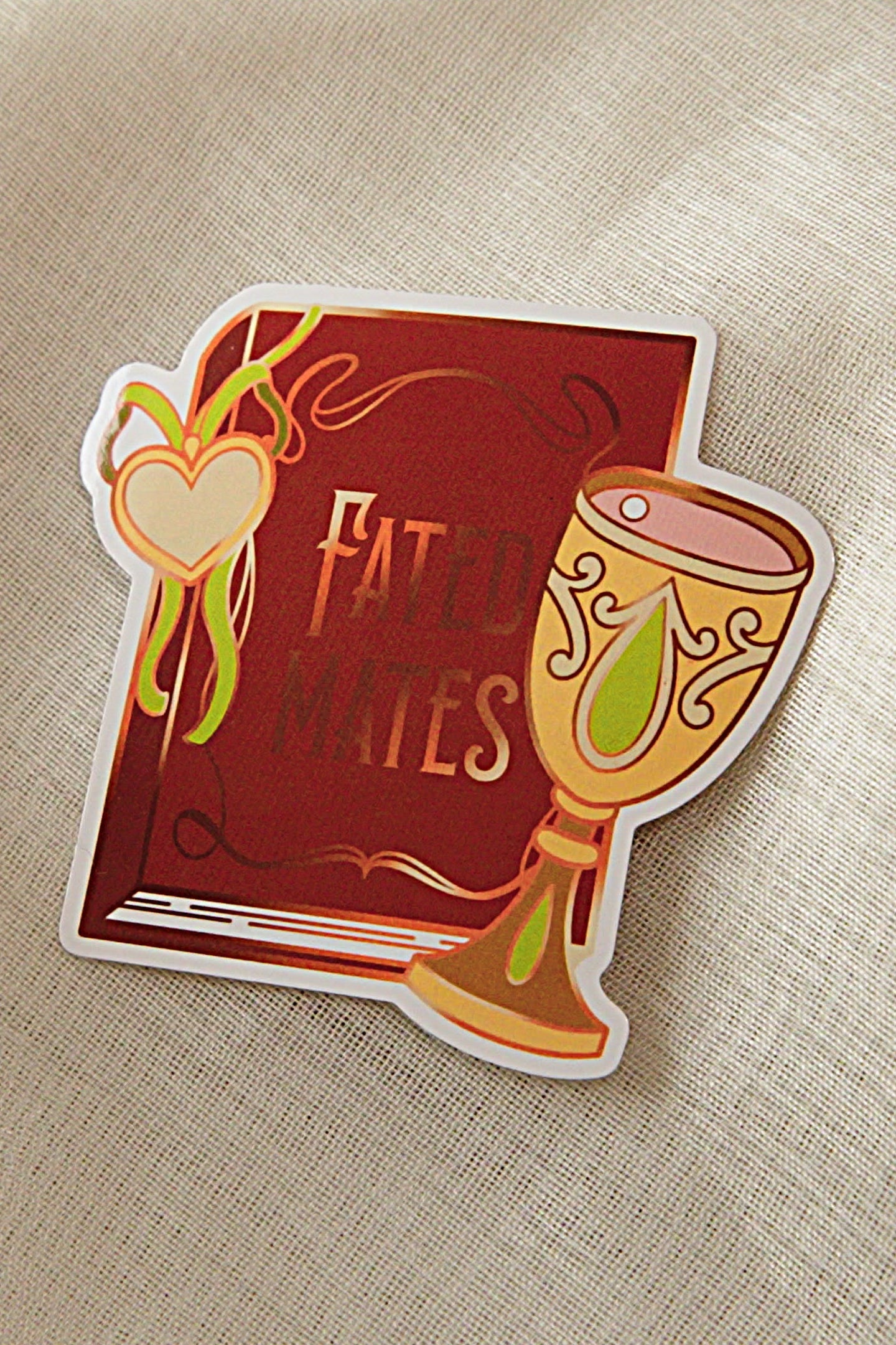 Sticker with a book and goblet design on a textured beige background
